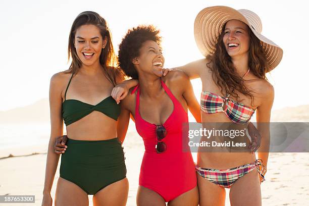 smiling women at beach - women's swimwear stock pictures, royalty-free photos & images