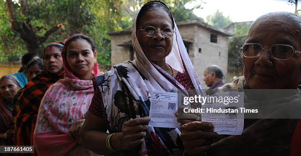 Voters showing their voter Id card standing in queue to cast their vote at polling booth during the first phase of assembly elections of Chhattisgarh...