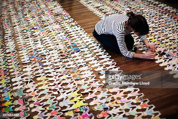 Volunteers put the finishing touches to a world record attempt at the longest chain of paper dolls ever at the Royal Festival Hall on November 11,...
