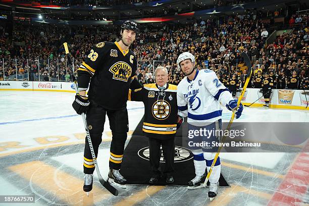 Paul Monti drops the puck before the game in honor of his son, who country singer Lee Brice wrote the song "I Drive Your Truck" for as he poses with...