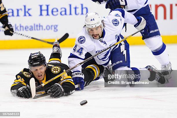 Carl Soderberg of the Boston Bruins fights for the puck against Nate Thompson of the Tampa Bay Lightning at the TD Garden on November 11, 2013 in...