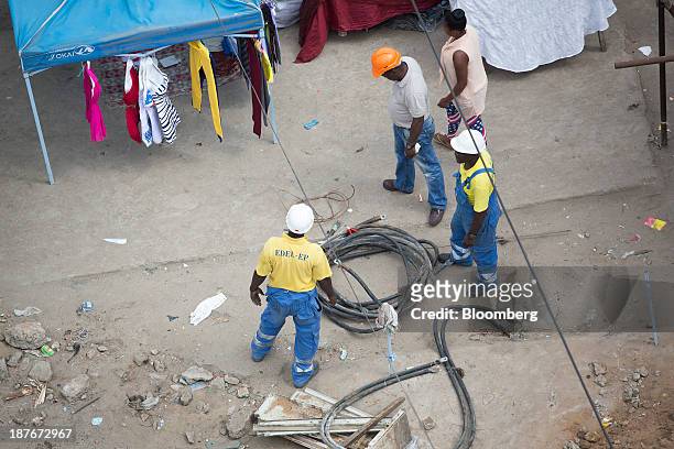 Electricity workers for Empresa de Distribuicao de Energia Electrica lay cables in Luanda, Angola, on Friday, Nov. 8, 2013. Angola, the largest crude...