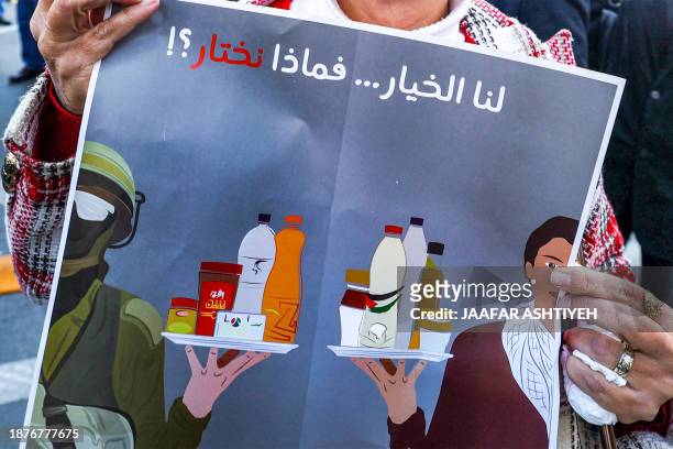 Woman holds a sign calling for the boycott of Israeli products during a demonstration in Ramallah in the occupied West Bank on December 26 as part of...