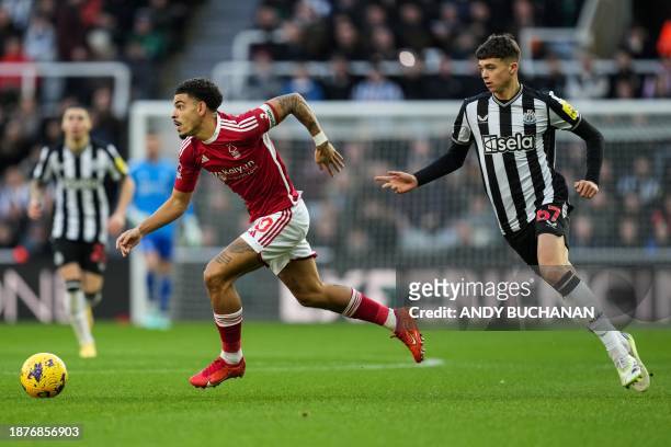Nottingham Forest's English midfielder Morgan Gibbs-White runs with the ball past Newcastle United's English midfielder Lewis Miley during the...