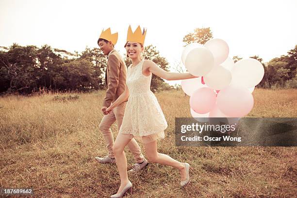 young couple is running on the grass with balloons - just married stock pictures, royalty-free photos & images