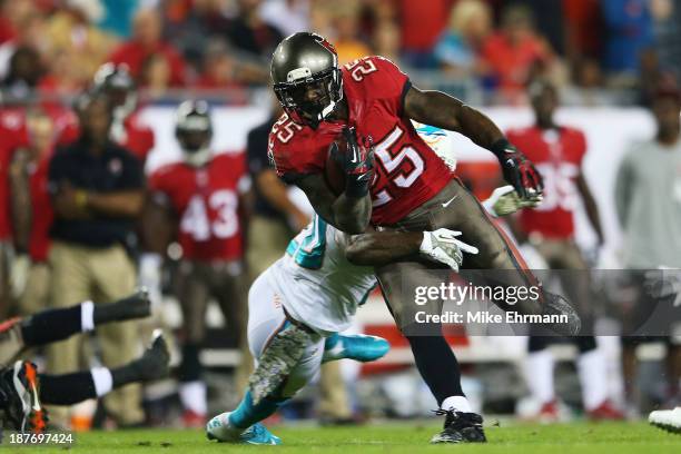 Mike James of the Tampa Bay Buccaneers tries to break the tackle of Reshad Jones of the Miami Dolphins in the first quarter at Raymond James Stadium...