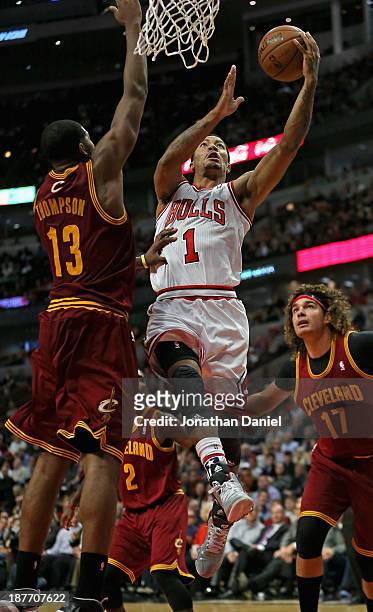 Derrick Rose of the Chicago Bulls drives to the basket between Tristan Thompson and Anderson Varejao of the Cleveland Cavaliers at the United Center...