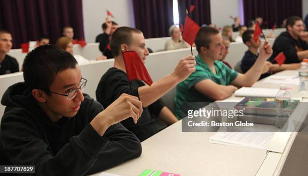 Shawsheen Valley Tech students wave red flags to signal warning signs of fraud during an exercise on Wednesday afternoon in a financial literacy...