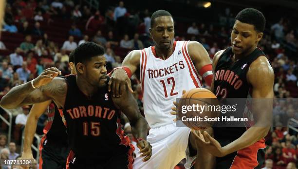 Dwight Howard of the Houston Rockets battles for the ball with Amir Johnson and Rudy Gay of the Toronto Raptors at Toyota Center on November 11, 2013...