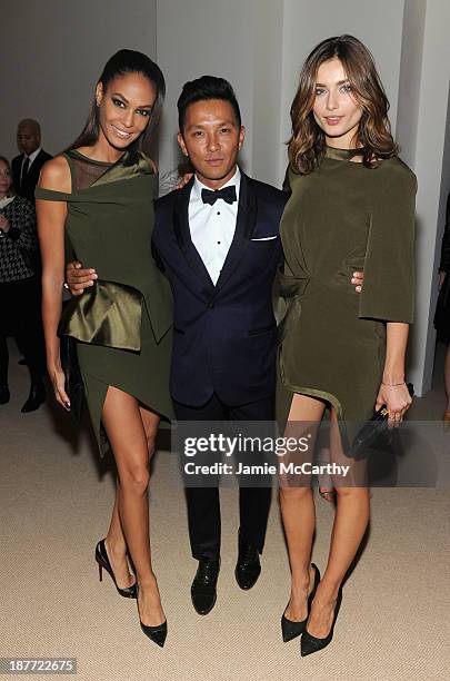 Designer Prabal Gurung poses with model Joan Smalls and guest at CFDA and Vogue 2013 Fashion Fund Finalists Celebration at Spring Studios on November...