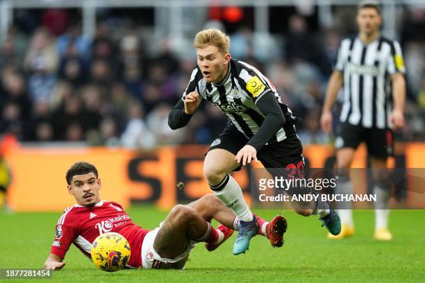 Nottingham Forest's English midfielder Morgan Gibbs-White fights for the ball with Newcastle United's English midfielder Lewis Hall during the...
