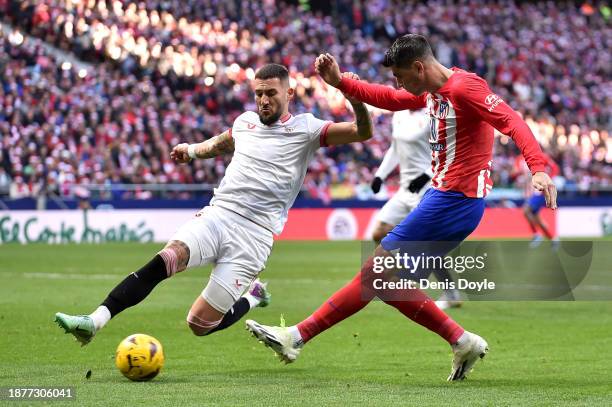 Alvaro Morata of Atletico Madrid crosses the ball whilst under pressure from Nemanja Gudelj of Sevilla FC during the LaLiga EA Sports match between...
