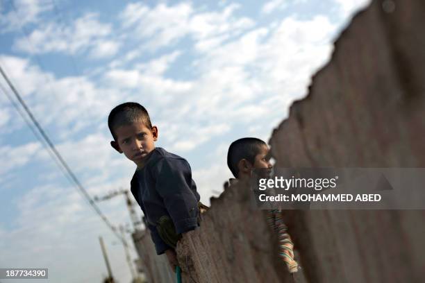 Palestinian boys watch as Islamist movement Hamas policmen jog along the streets in Gaza City on November 12 three days before the first anniversary...