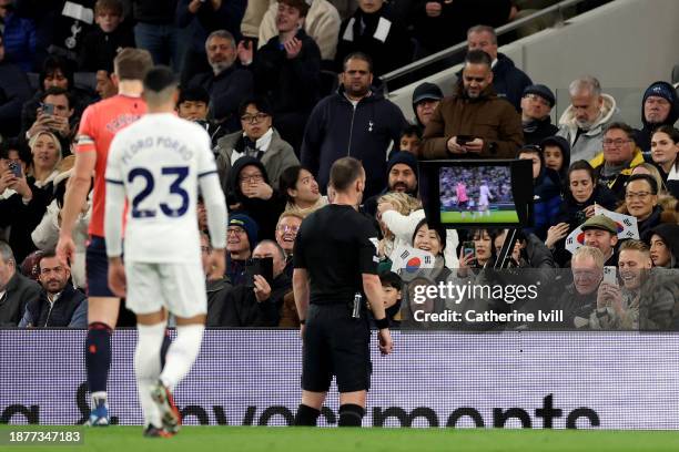 Referee Stuart Attwell refers to the on-field VAR screen to review and later disallow the goal scored by Dominic Calvert-Lewin of Everton during the...