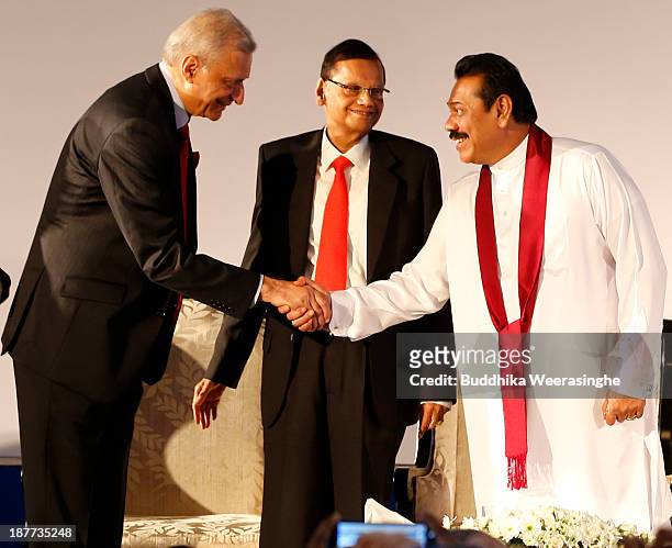 Sri Lankan President Mahinda Rajapaksa shakes hands with Commonwealth Secretary-General Kamalesh Sharma as Sri Lankan Foreign Minister Gamini...