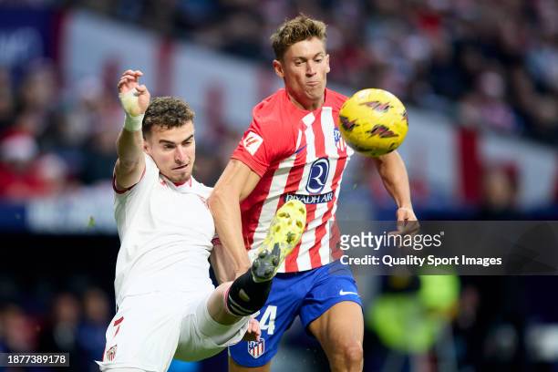 Marcos Llorente of Atletico de Madrid competes for the ball with Adria Pedrosa of Sevilla FC during the LaLiga EA Sports match between Atletico...