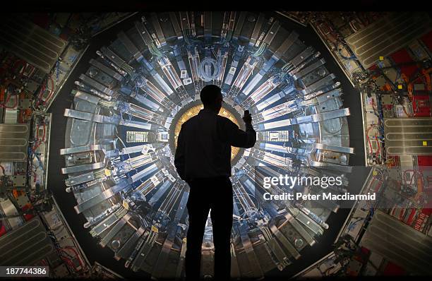 Visitor takes a phone photograph of a large back lit image of the Large Hadron Collider at the Science Museum's 'Collider' exhibition on November 12,...