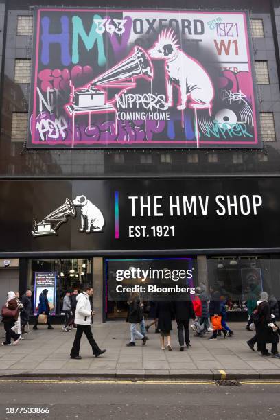 Shoppers pass the HMV flagship music store, recently reopened, on Oxford Street during traditional Boxing Day holiday sales, in London, UK, on...