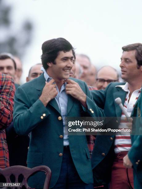 Severiano Ballesteros of Spain is presented with the Green Jacket by the previous year's winner Fuzzy Zoeller of the United States after winning the...