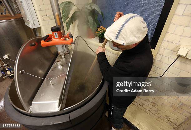 Johannes Heidenpeter, owner of Heidenpeters brewery, stirs the mixture after adding hops while brewing Thirsty Lady American Pale Ale beer on...