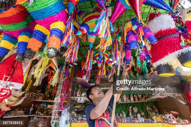 Vendor arranges his piñatas at his street stall ahead of Christmas celebrations on December 22, 2023 in Mexico City, Mexico.