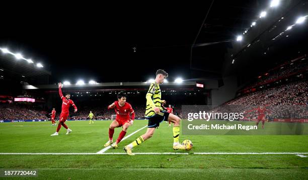 Kai Havertz of Arsenal runs with the ball whilst under pressure from Wataru Endo of Liverpool during the Premier League match between Liverpool FC...