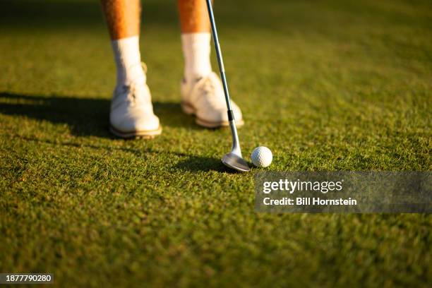 a young golfer gets ready to hit a chip shot with a sandwedge from the fairway of a golf course. - lob wedge stock pictures, royalty-free photos & images