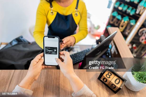 customer paying using smartphone in a store - entrepreneur stockfoto's en -beelden