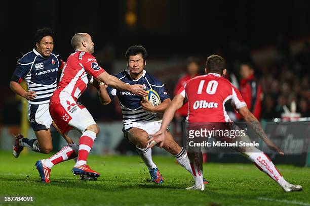 Yuta Imamura of Japan cuts between Charlie Sharples and Ryan Mills of Gloucester during the International match between Gloucester and Japan at...