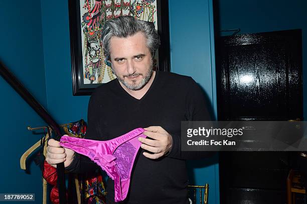 Writer Nicolas Rey poses with a piece of lingerie from the 'RougeGorge' collection during the 'RougeGorge' Women Underwear Exhibition Hosted By...
