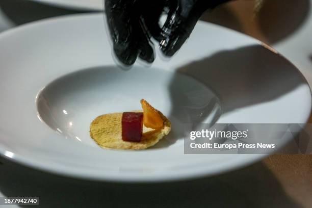 Person serves dishes during a charity dinner at the Mirador de Cuatro Vientos, on 23 December, 2023 in Madrid, Spain. The solidarity initiative 'I...