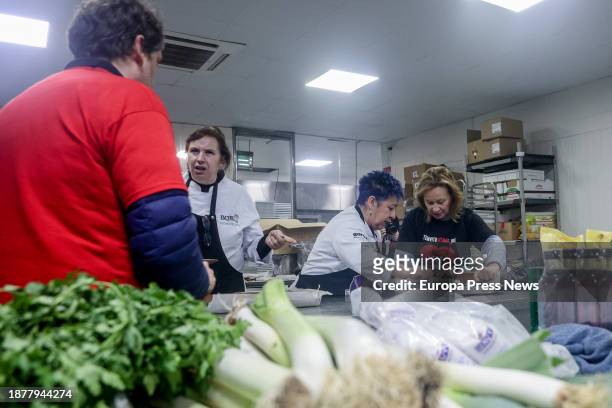 Several people cook for a charity dinner at the Mirador de Cuatro Vientos, on 23 December, 2023 in Madrid, Spain. The solidarity initiative 'I invite...
