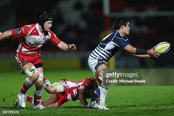 Yu Tamura of Japan offloads as Ryan Mills of Gloucester clings on during the International match between Gloucester and Japan at Kingsholm Stadium on...