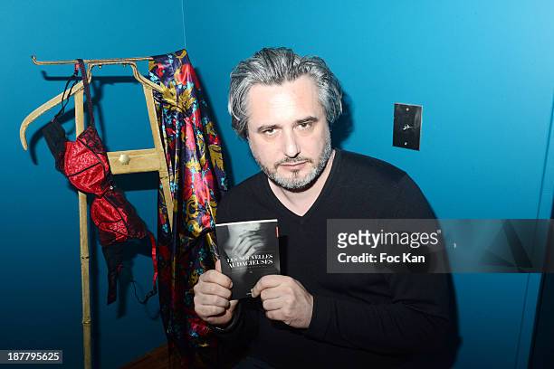 Writer Nicolas Rey poses with 'Les Nouvelles Audacieuses' his short stories book inspired by the RougeGorge lingerie during the 'RougeGorge' Women...