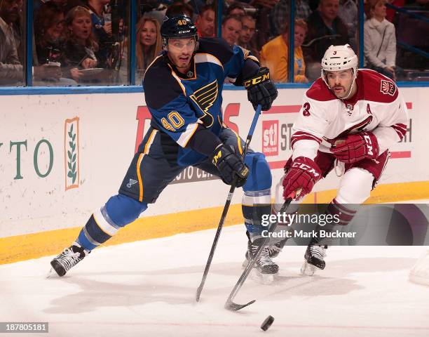 Maxim Lapierre of the St. Louis Blues battles Keith Yandle of the Phoenix Coyotes for the loose puck on November 12, 2013 at Scottrade Center in St....