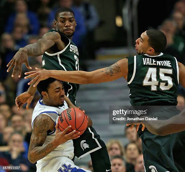 Denzel Valentine of the Michigan State Spartans smacks James Young of the Kentucky Wildcats in the head as Branden Dawson defends during the State...