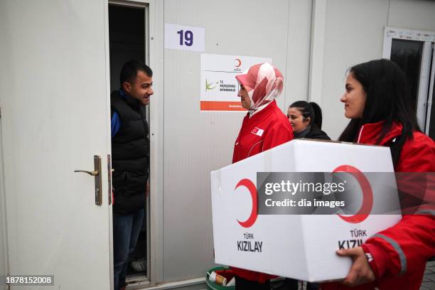 People receive aid from the Turkish Red Crescent humanitarian aid organization on December 23, 2023 in Hatay Turkey. Turkish Red Crescent distributed...