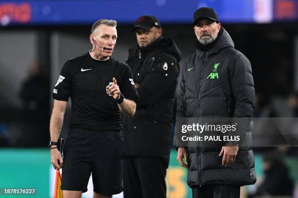 The assistant referee speaks with Liverpool's German manager Jurgen Klopp during the English Premier League football match between Burnley and...