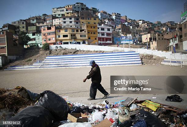 Claudio, who said he earns about $3.50 U.S. Dollars per day collecting discarded recyclables, walks while working on November 12, 2013 in Lima, Peru....