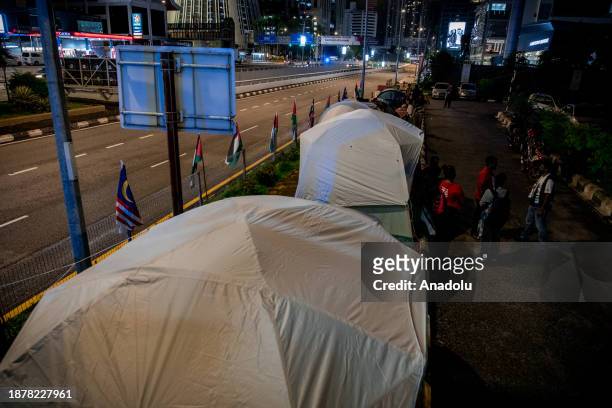Demonstrators holding banners and Palestinian flags set up tents as they gather near the United States embassy in solidarity with Palestinian people...