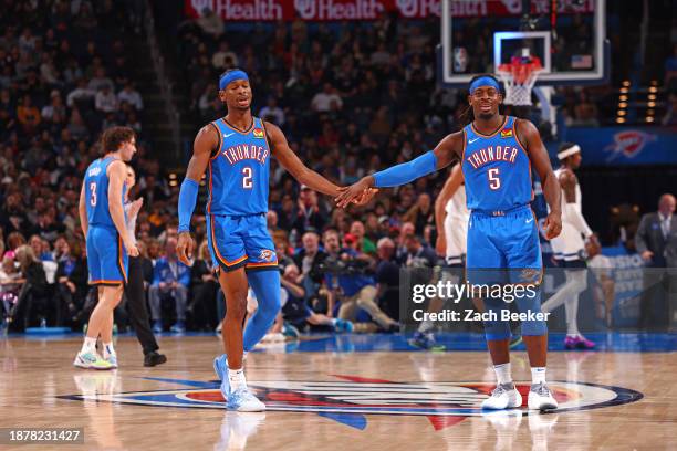 Shai Gilgeous-Alexander high fives Luguentz Dort of the Oklahoma City Thunder during the game against the Minnesota Timberwolves on December 26, 2023...