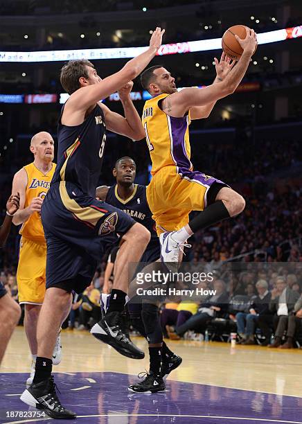 Jordan Farmar of the Los Angeles Lakers attempts a layup in front of Jeff Withey of the New Orleans Pelicans during a 116-95 Laker win at Staples...