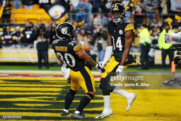 George Pickens of the Pittsburgh Steelers celebrates after scoring a touchdown with his teammate Jaylen Warren during the third quarter of a game...