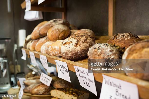 artisan bread on shelves in bakery. - bread shop stock pictures, royalty-free photos & images
