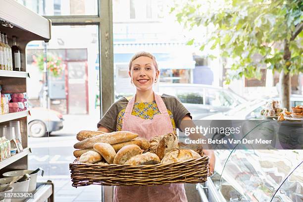 shop assistant holding basket with artisanbreads - leanincollection stock pictures, royalty-free photos & images