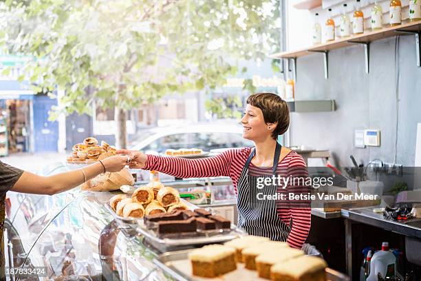 shopkeeper serving customer in delicatessen shop - pasticceria foto e immagini stock