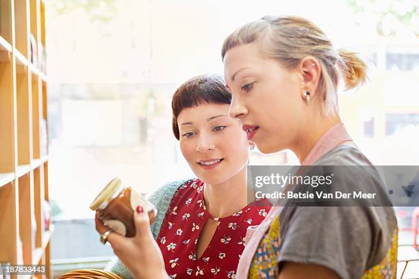 shop assistant and customer looking at food label. - shopping candid stock pictures, royalty-free photos & images