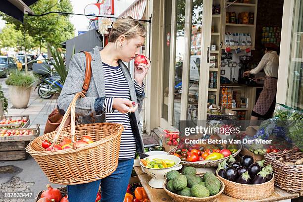 woman smells fruit shopping in fruitstall. - london food stock pictures, royalty-free photos & images