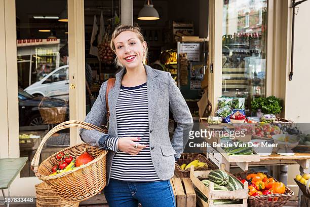 woman with shopping basket with organic vegetables - bio supermarkt stockfoto's en -beelden