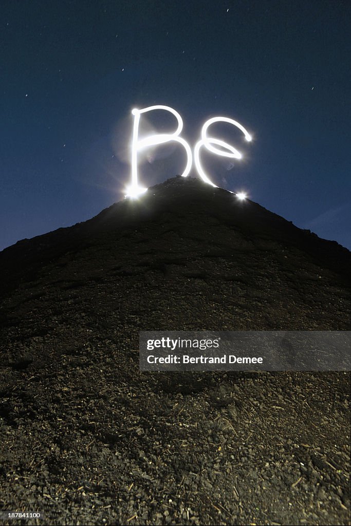 'BE' write in light on the top of hill